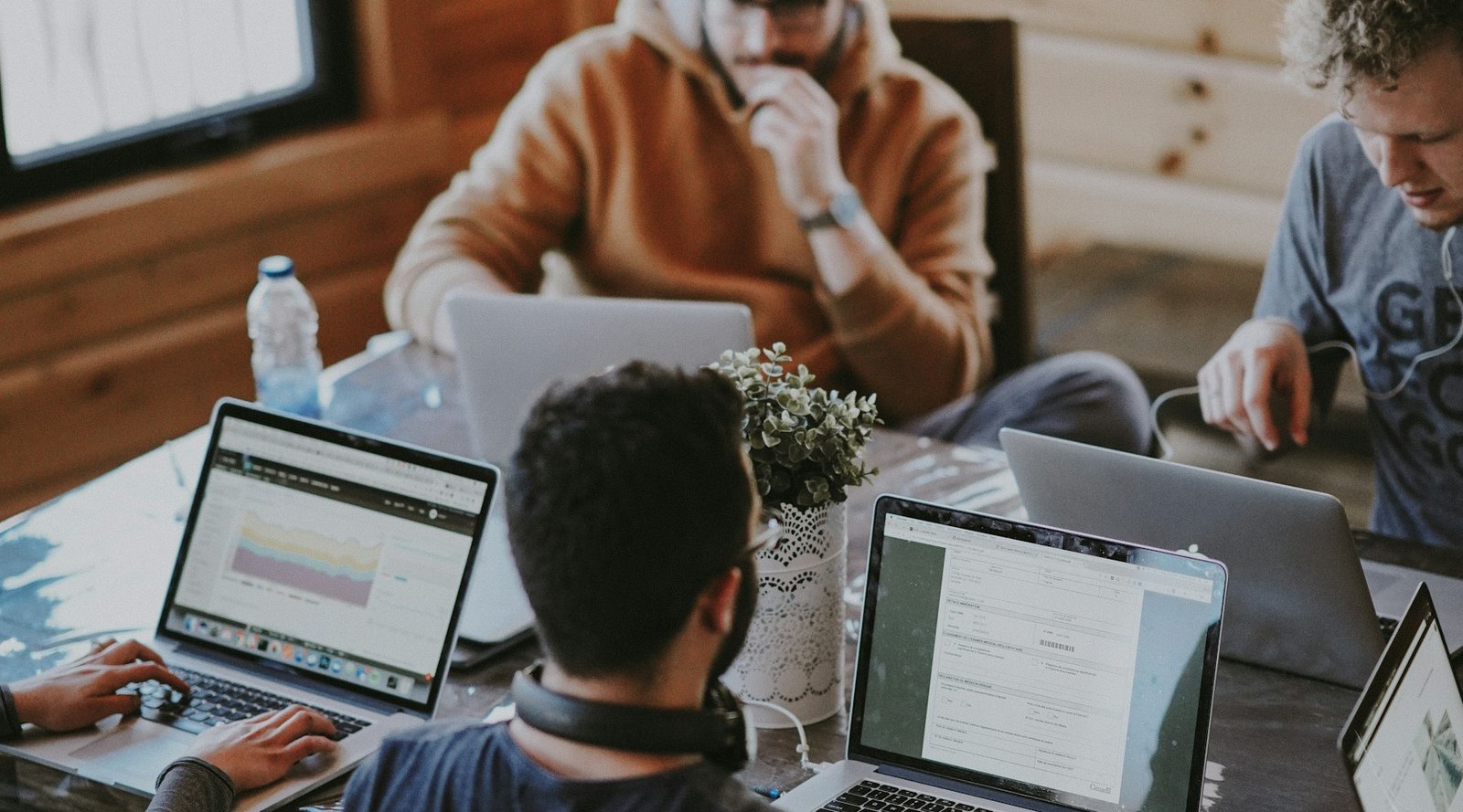 People collaborating around laptops in a shared workspace